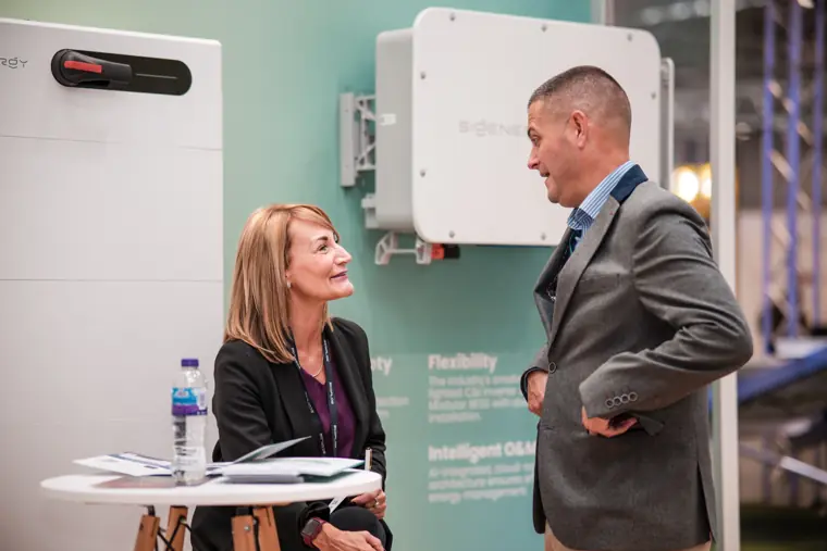 An attendee meeting a visitor at the stand.