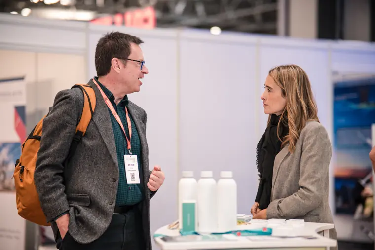 A conversation around the exhibition counter.