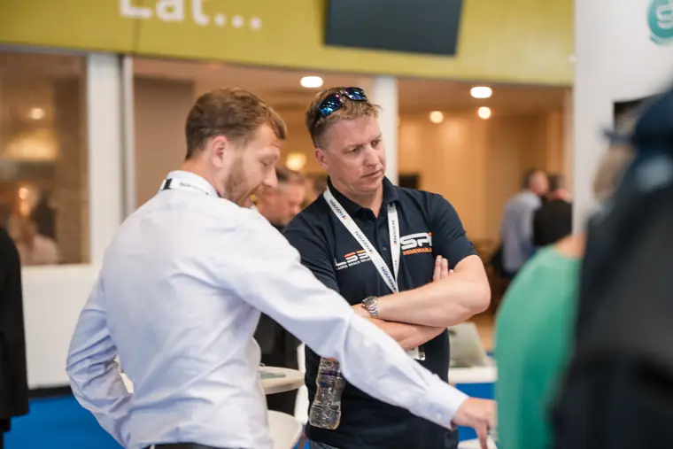 A team member demonstrates a product to a visitor.