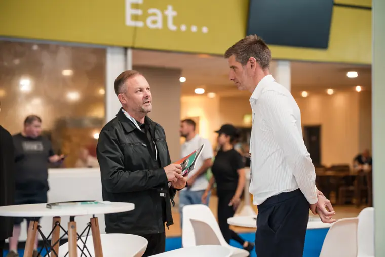 Two visitors greet each other at the exhibition.