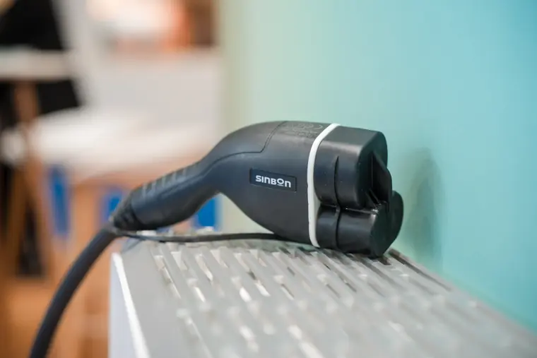 An EV charging connector on the stand.