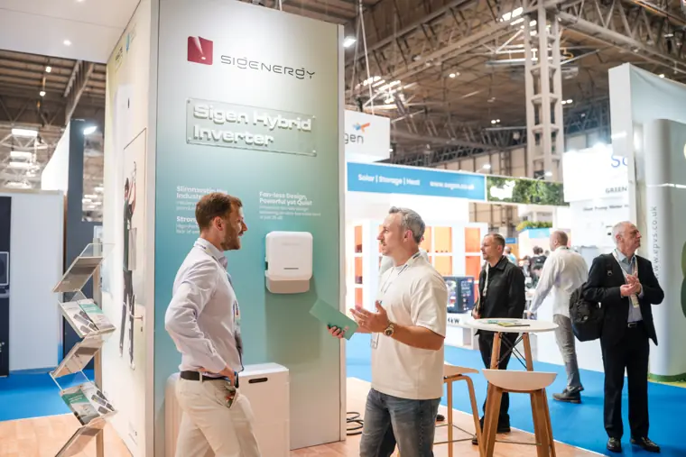 Visitors speak at the front of the stand.