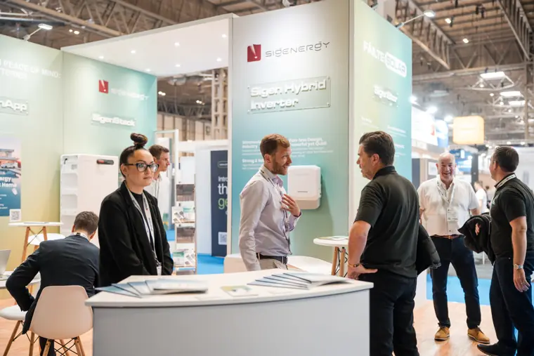 The team speaks with guests around the stand.