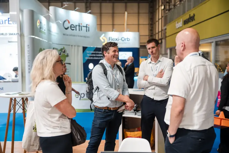 A group discusses a system on the show floor.