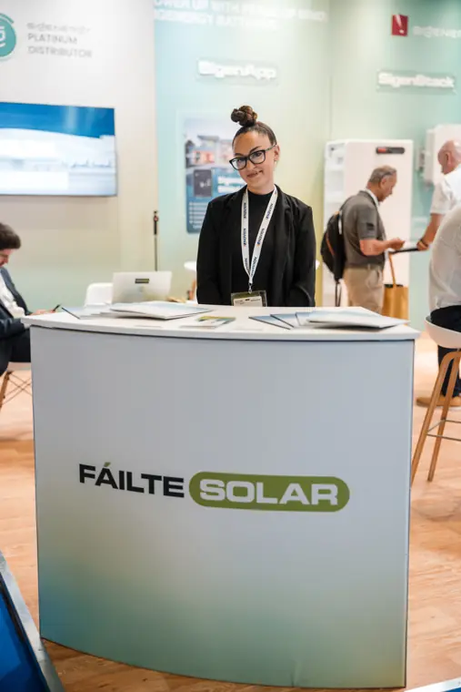 A visitor stands at the branded reception desk.