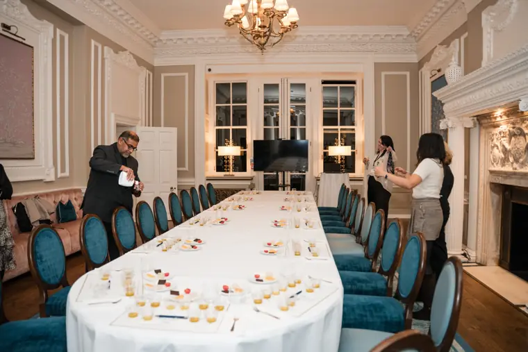 Hosts welcoming guests around the long table.