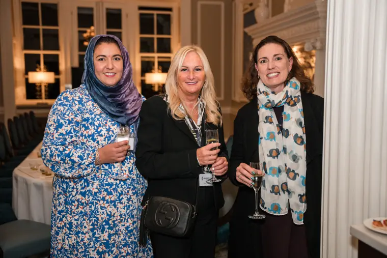 Three guests posing together during the reception.