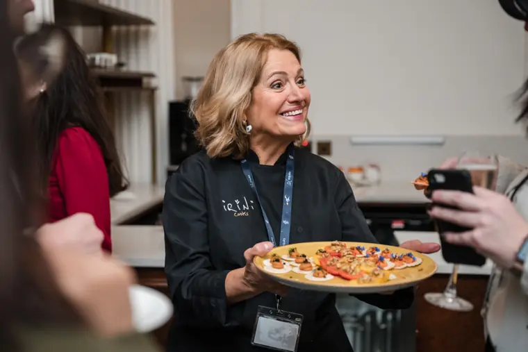 Host serving small plates to attendees.