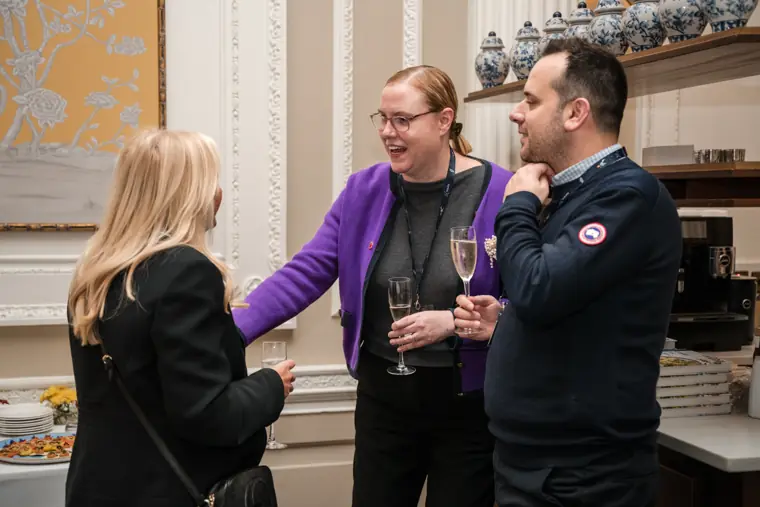 Guests talking beside the tasting table.