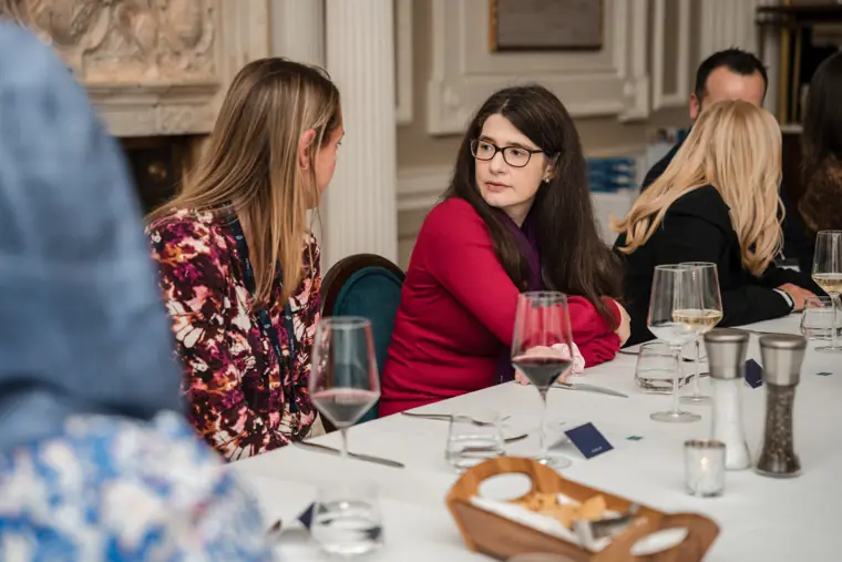 Two attendees in conversation over dinner.