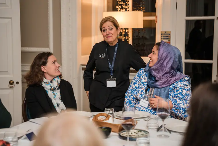 Host speaking with attendees during dinner.