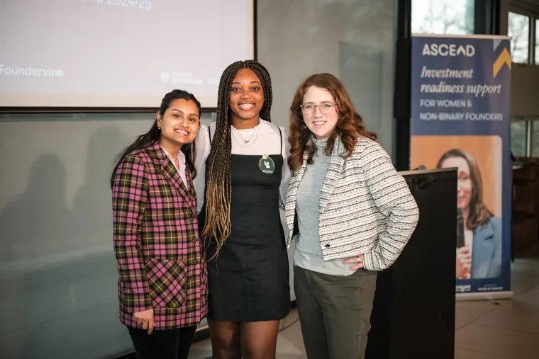 Three participants pose by the Ascend investment readiness sign.