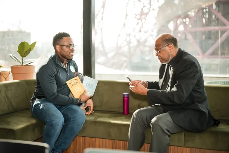 Two attendees discuss a founder programme handout.