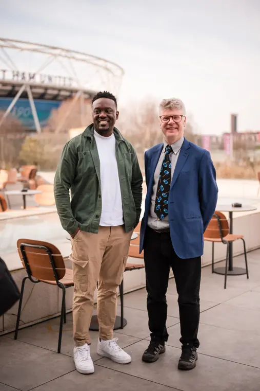 Two attendees pose together on the venue terrace.