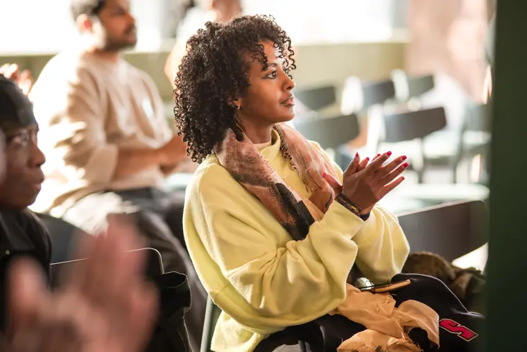 An audience member applauds after a presentation.