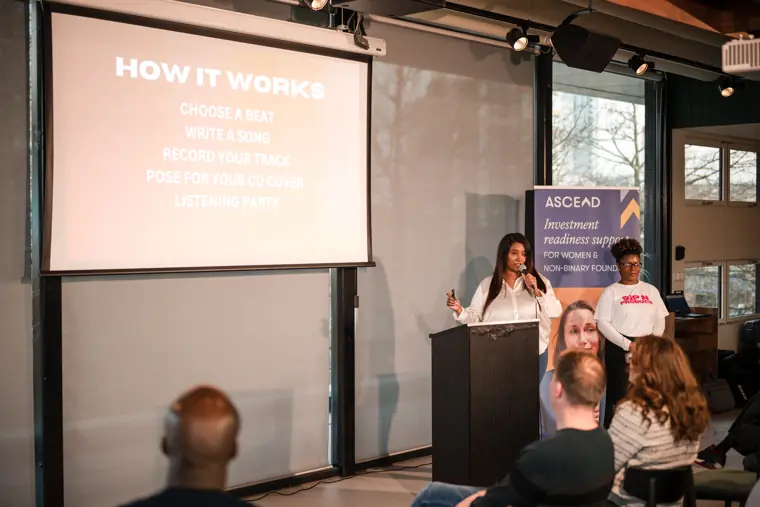 A wide view of two founders introducing their work.