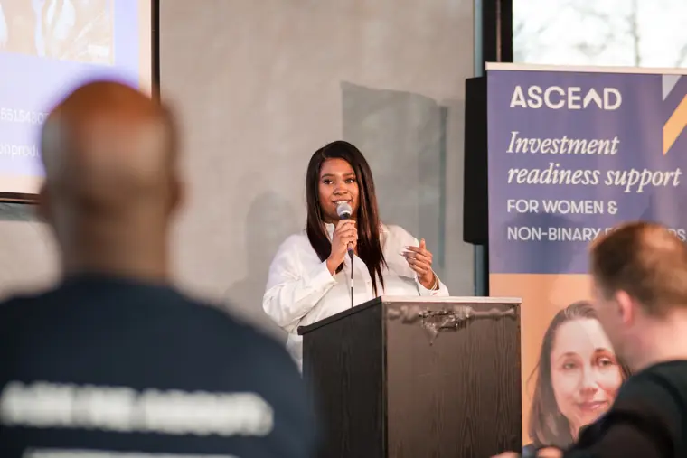 A founder speaks beside the Ascend investment readiness banner.