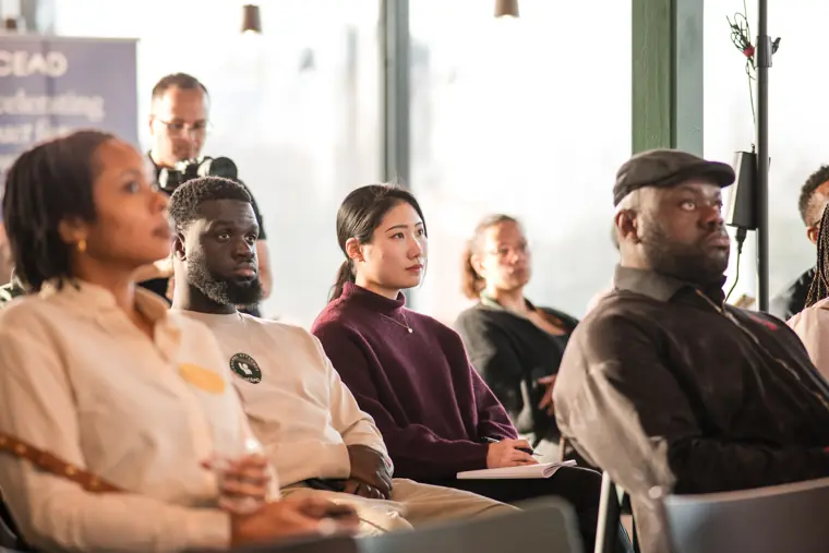 The audience listens to the founder pitches.