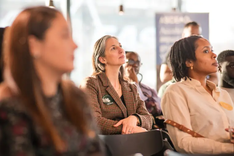 An attendee watches a speaker from the front row.