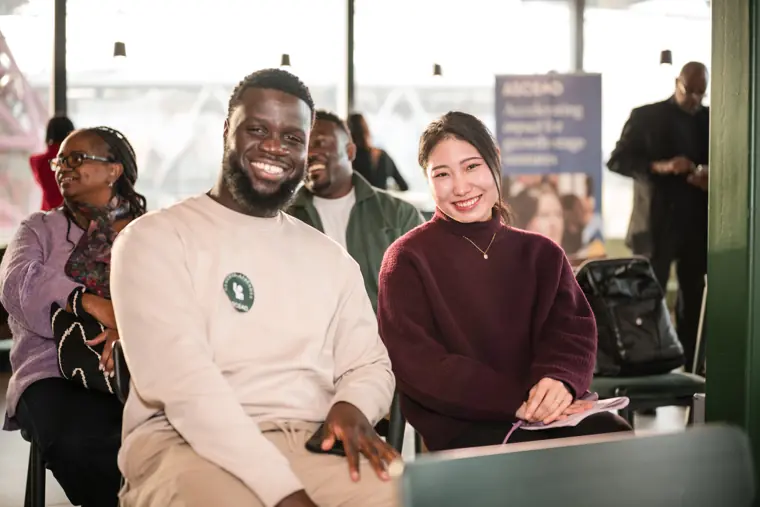 Three guests smile during the closing session.