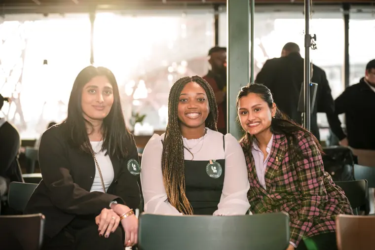 Three women pose together in the reception area.