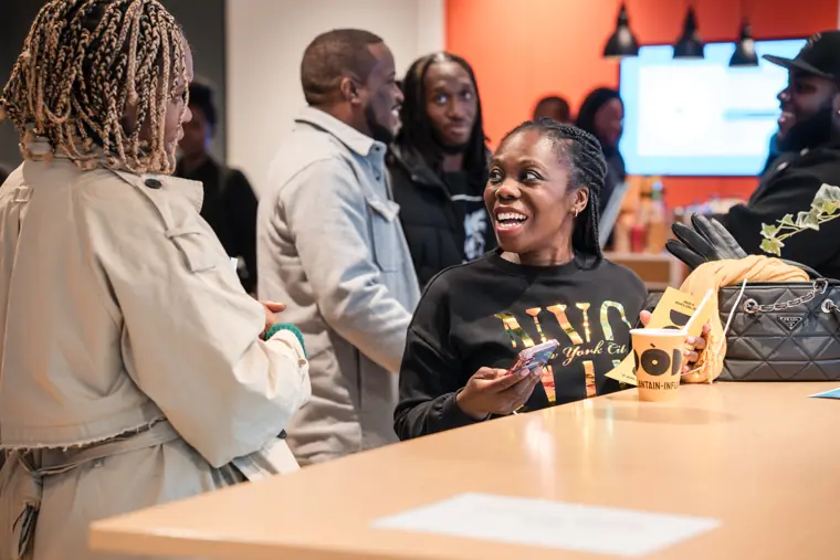Guests share a laugh at the drinks counter.