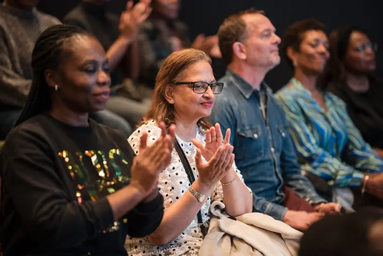 Audience members applaud the introduction.