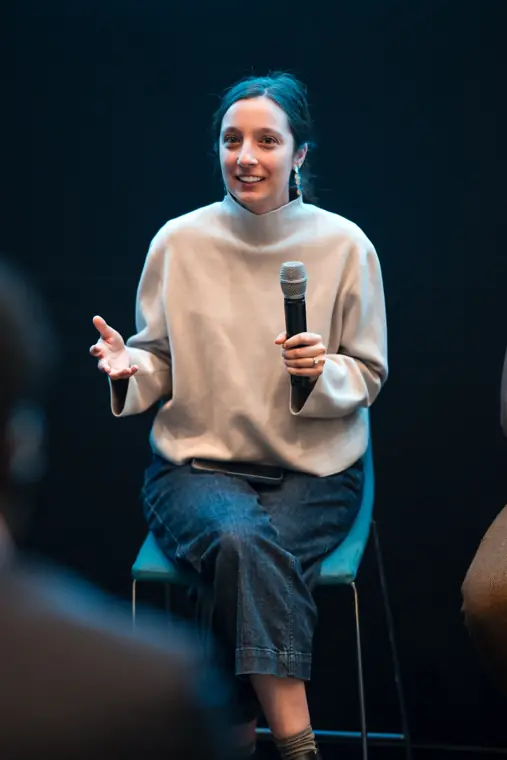 A founder speaks from the front of the room.