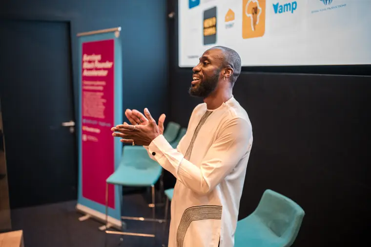 A speaker presents beside the accelerator banner.