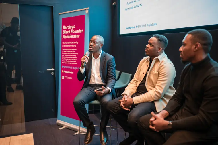 Three panelists answer questions on stage.