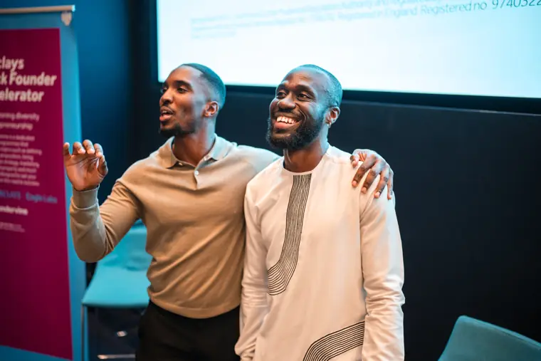 Two founders celebrate together on stage.