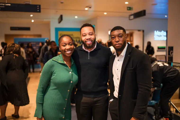 A founder smiles with two guests.