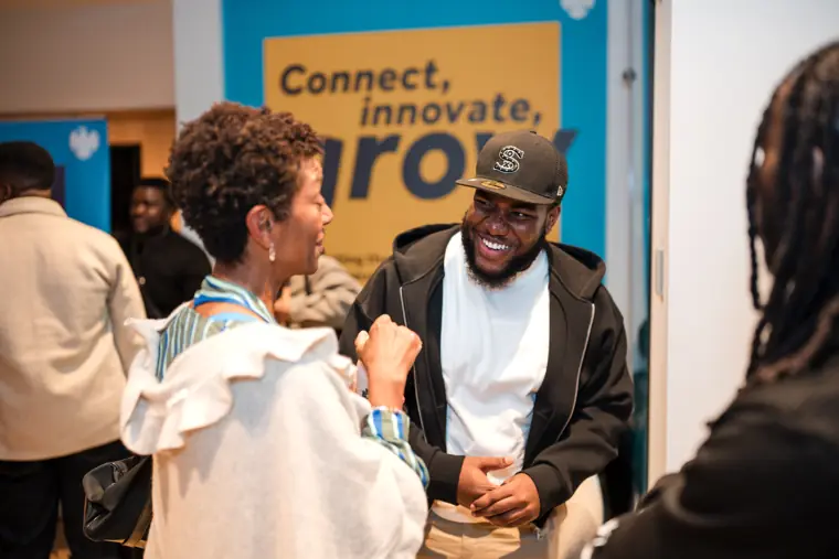 Guests talk beside the Foundervine banner.