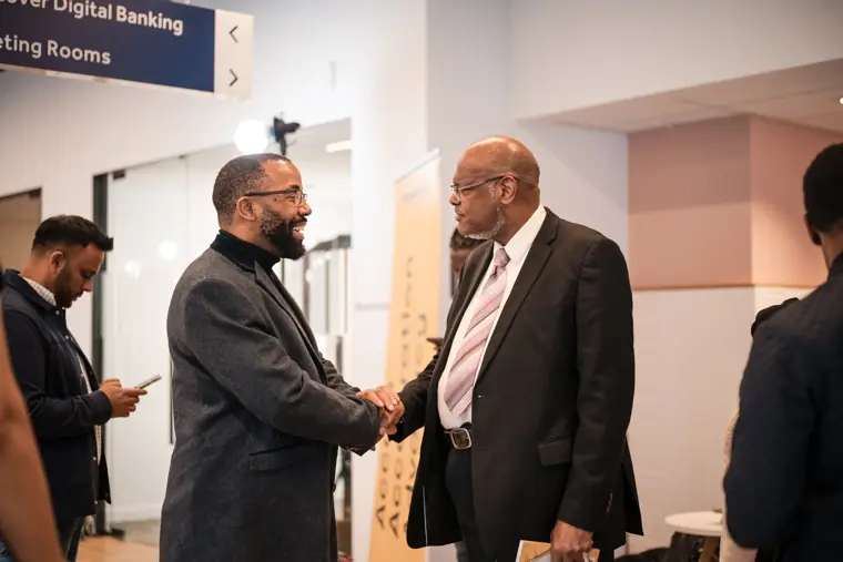 Two guests shake hands during the networking break.