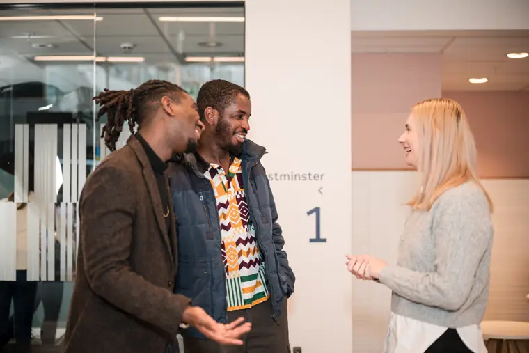 A founder speaks with two guests by the venue doors.