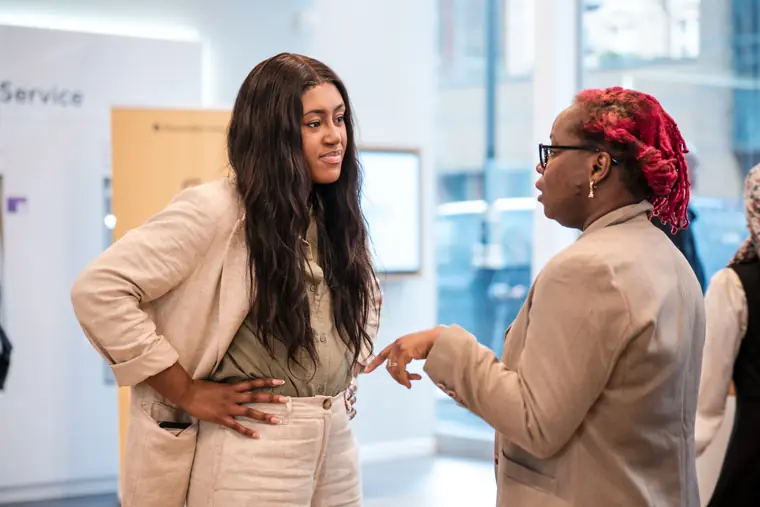 Two guests share a conversation near the venue wall.