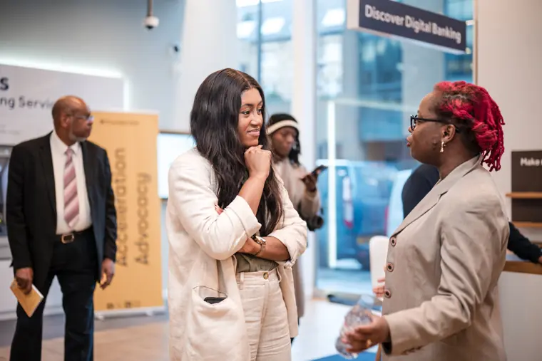 A speaker talks with a guest near the venue entrance.