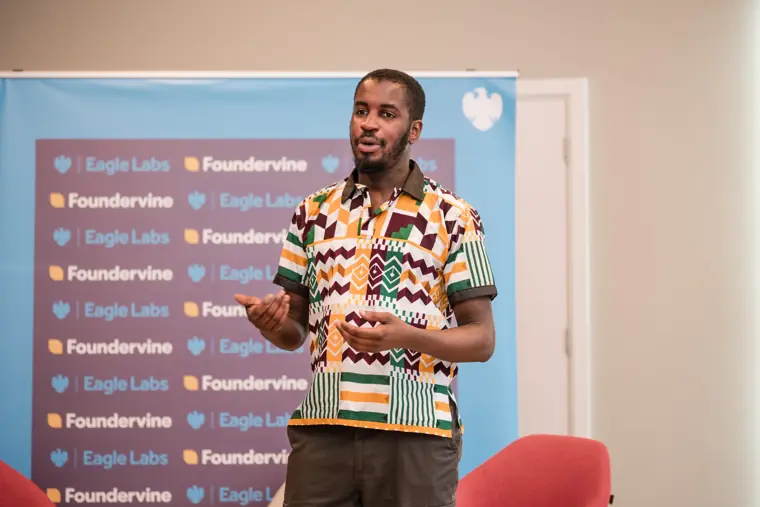 A founder speaks in front of the Foundervine backdrop.