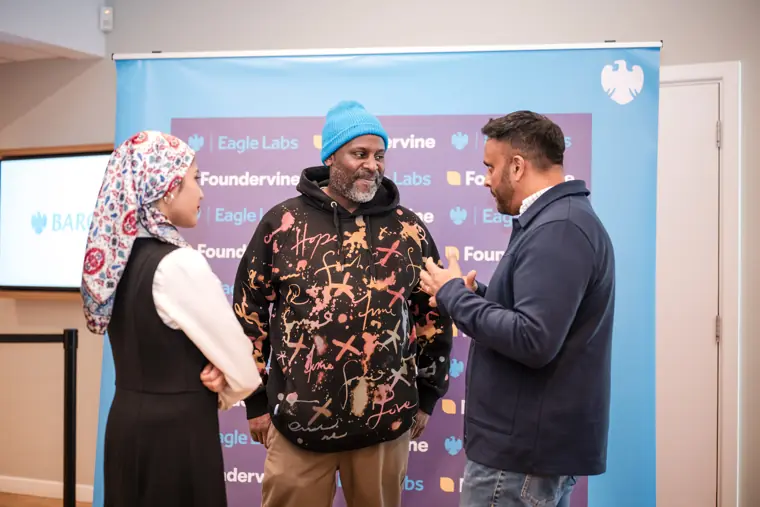Three guests exchange ideas during networking.