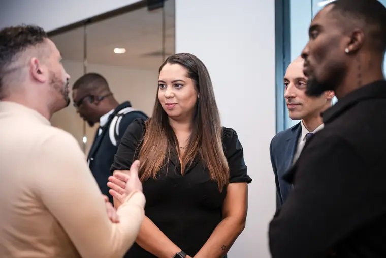 Two attendees look at a phone together.
