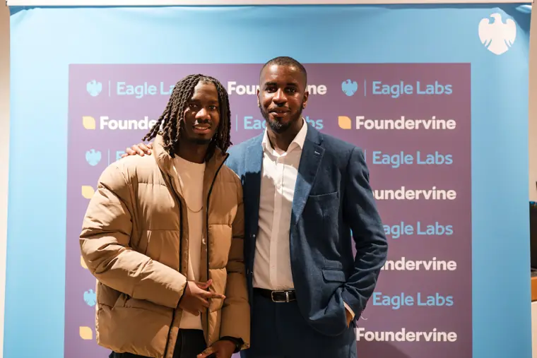 Founders pose beside the partner backdrop.