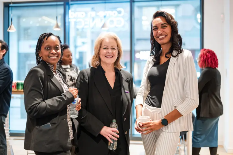 Three attendees pose together.