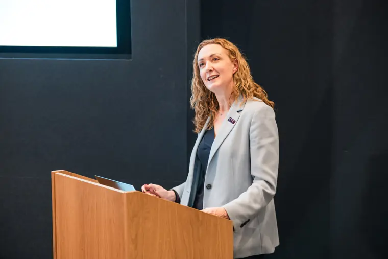 A speaker pauses at the lectern.