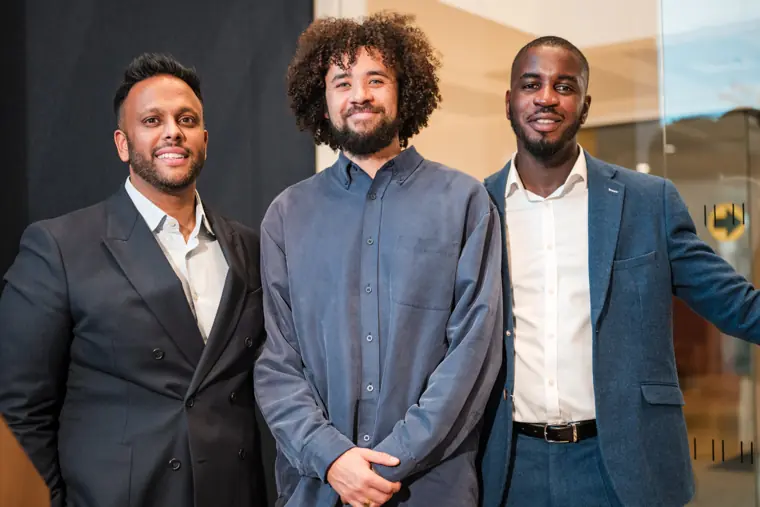 Three founders pose together after the pitches.