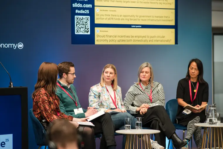 Speakers discuss circular economy on stage.