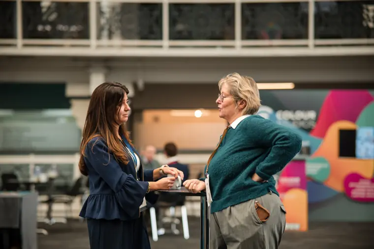 Visitors networking beside the exhibition stands.