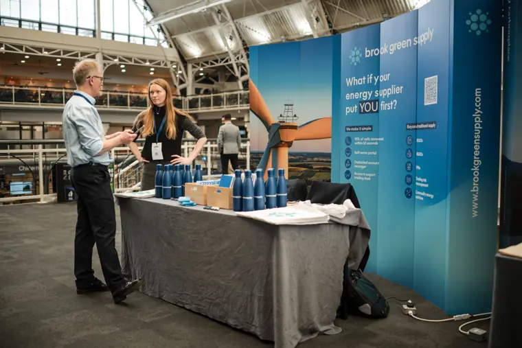 Visitors talking at an exhibition stand.