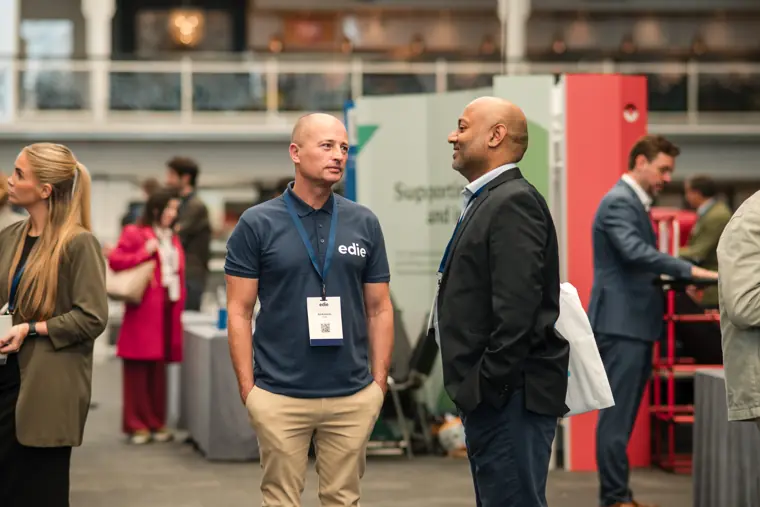 Attendees talking on the exhibition floor.