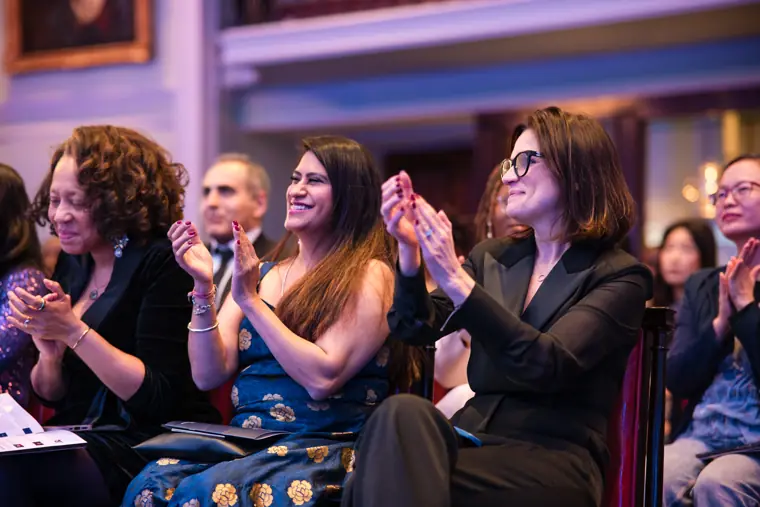 Audience members applaud a presentation.