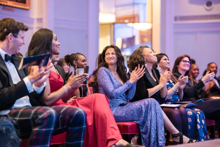 Guests applaud from their seats.